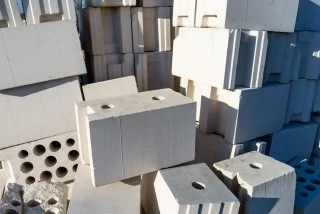 Staplade betongblock med hål utomhus i solljus med tydliga skuggor.